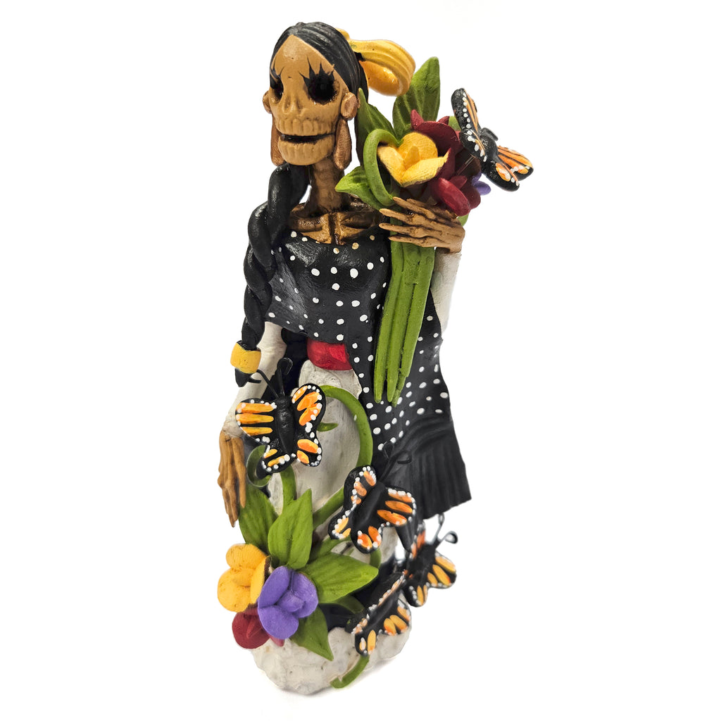 Beautiful Catrina dressed in black with basket of flowers and butterflies