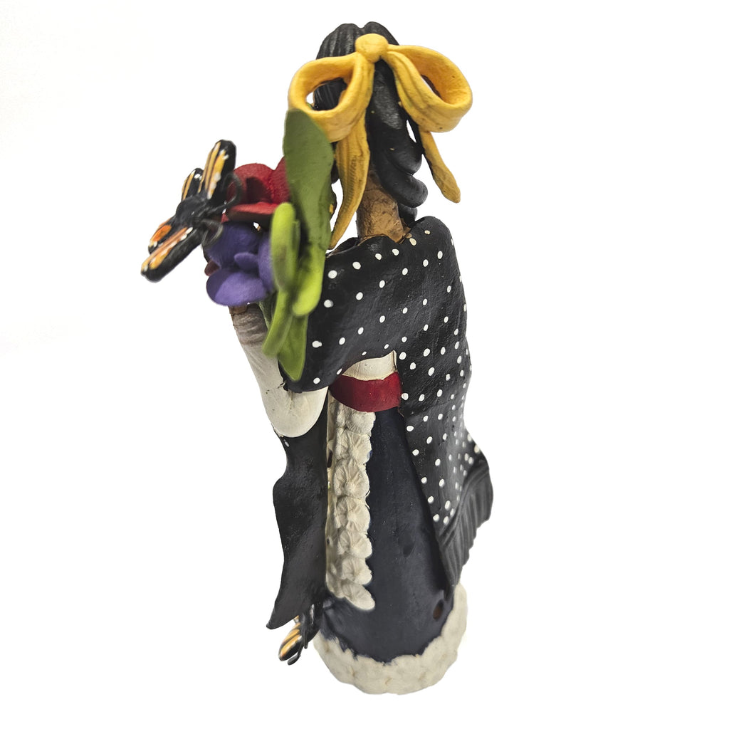 Beautiful Catrina dressed in black with basket of flowers and butterflies