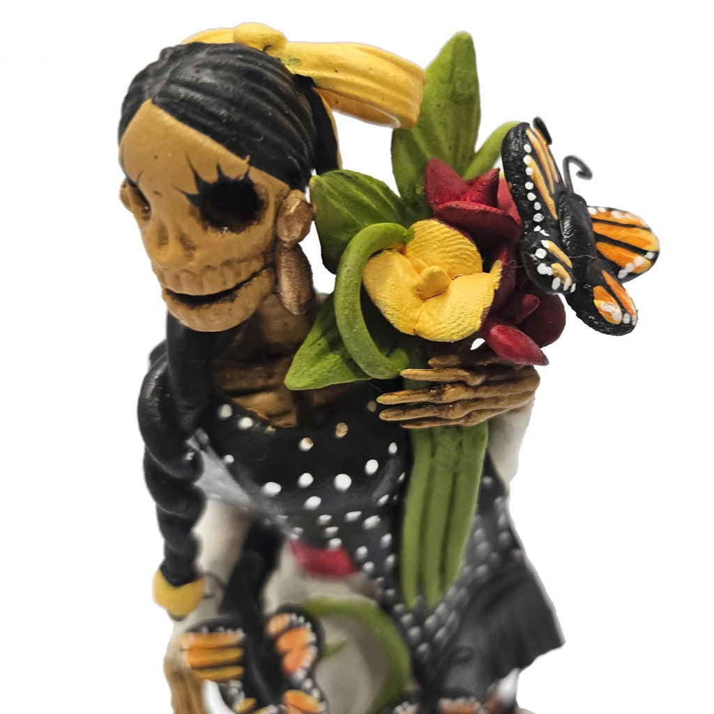 Beautiful Catrina dressed in black with basket of flowers and butterflies